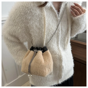 Vue détaillée du sac seau en peluche avec cordon de serrage, perles et chaîne argentée