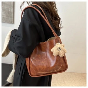 Sac cabas marron en similicuir avec un charme étoile en peluche vu de profil par derrière