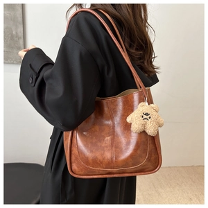 Vue détaillée d'un sac cabas marron vintage avec un pendentif étoile et des surpiqûres