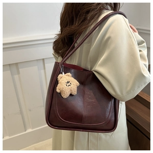 Détail du sac cabas bordeaux avec texture cuir et adorable charme étoile en peluche