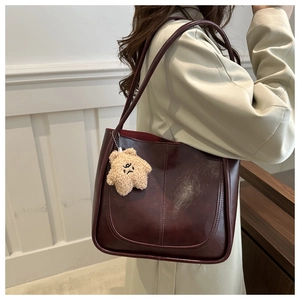 Détail d'un sac cabas bordeaux en cuir rétro avec un charmant pendentif étoile
