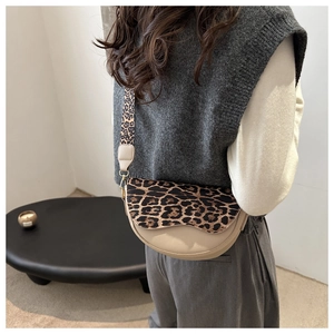 Detail of leopard print patchwork saddle bag on shoulder with wide adjustable strap