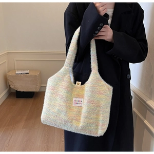 Detailansicht der Regenbogen-Plüschtasche mit weicher Strickstruktur und goldenem Druckknopf