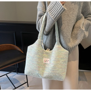 Detailansicht der flauschigen Makronen-Stricktasche mit Metallknopf und gewebtem Etikett