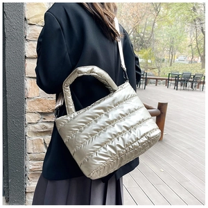 Detail of champagne silver quilted tote bag with detachable strap and metallic finish