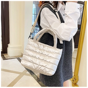 Detail of quilted tote bag with metallic finish and detachable wide shoulder strap