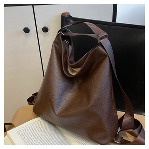 Close-up of a large dark brown tote bag with textured faux leather and a wide shoulder strap