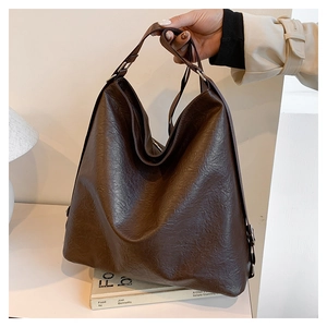 Macro detail of high-quality dark brown soft leather tote with natural textures