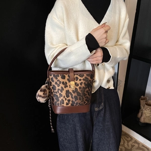 Fashionable leopard print bucket bag with leather trim and gold twist lock closure