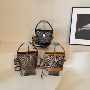 Three leopard print bucket bags with leather handles and faux fur pompom charms