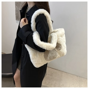 Close-up of white and taupe faux fur tote bag showing plush texture on model shoulder