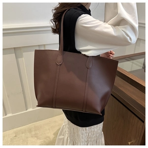 Brown leather tote bag featuring long shoulder straps for casual commute style