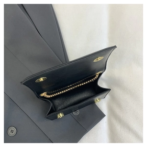 Top view of black PU leather mini flap bag with gold magnetic buckle and fine chain strap