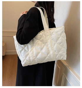 Dettaglio della borsa tote trapuntata oversize bianco crema con etichetta logo
