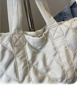 Dettaglio della borsa tote in nylon bianco trapuntato con motivo a rombi e patch