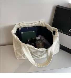 Vista interna della capiente borsa shopper trapuntata color crema con ampio spazio