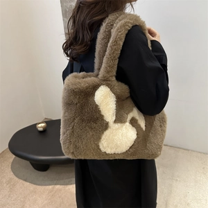 Brown fluffy plush tote bag with white rabbit silhouette for women on shoulder