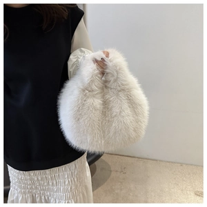 Detailed texture of white plush faux fur on a fluffy handbag for autumn and winter