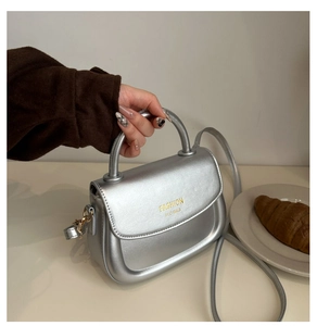 Silver metallic saddle bag with round handle and gold Fashion H.C logo detail