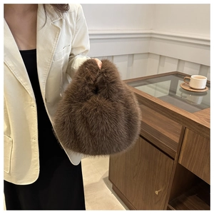 Detail of soft brown faux fur handbag texture and ergonomic handle in a lifestyle setting