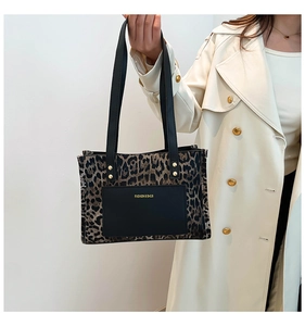 Dettaglio della borsa shopper leopardata con tasca in pelle nera e logo fashion