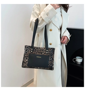 Dettaglio della borsa tote leopardata con tasca nera e lunghi spallacci sottili