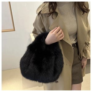 Close-up of black faux fur handbag texture and round fluffy handle for winter fashion