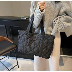 Dettaglio della borsa shopper nera trapuntata con tessuto in nylon lucido e trama a rombi