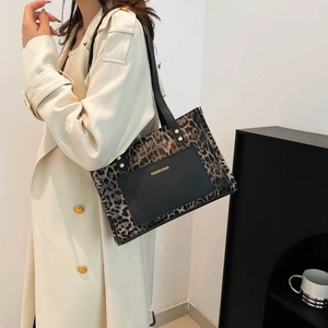 Chic leopard print tote bag with black leather pocket and gold rivet details for women