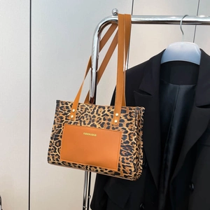 Borsa tote alla moda con stampa leopardata e manici in pelle marrone su supporto