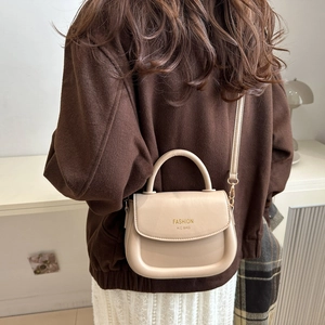 Chic beige leather saddle handbag with shoulder strap shown on model for women