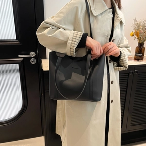 Fashionable black matte leather tote bag for women shown as model shoulder bag