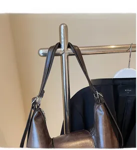 Detailed close-up of dark brown leather tote bag handle and textured vintage surface