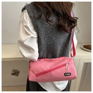 Sac bandoulière rose imperméable avec fermeture éclair diagonale et logo tendance