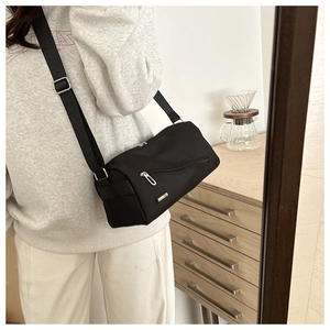 Vue détaillée du sac bandoulière en nylon noir avec sangle réglable en décor de vie