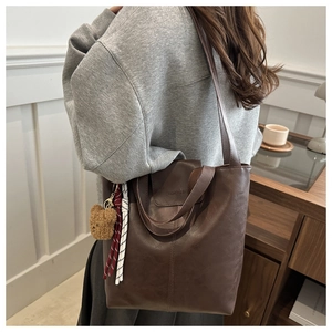 Detailed view of dark brown PU leather tote bag texture with fashion debossed logo