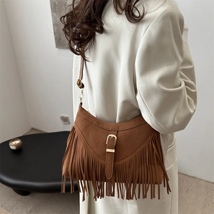 Brown suede fringed hobo bag in bohemian style shown on model for autumn fashion