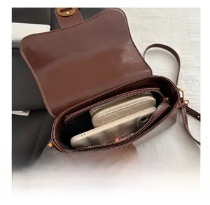 Vue intérieure du sac bandoulière marron montrant sa grande capacité pour portefeuille