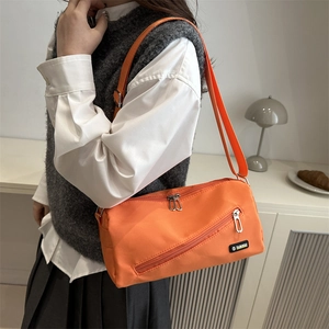 Sac bandoulière en nylon orange vif avec sangle réglable et poche zippée devant