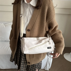 Sac bandoulière minimaliste en nylon beige avec étiquette fashion en situation réelle