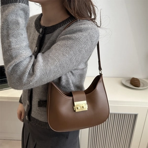 Deep brown leather hobo shoulder bag with a crescent shape and gold metal buckle