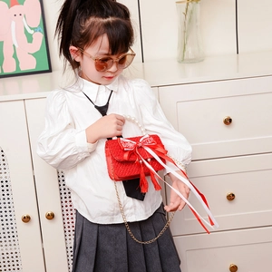 Borsa a tracolla rossa in tweed per bambine con manico di perle e fiocco indossata da bimba