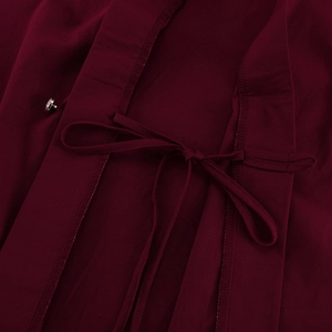 Detail aus burgunderfarbenem Texturgewebe mit Bindeband und silberner Strass-Schnalle