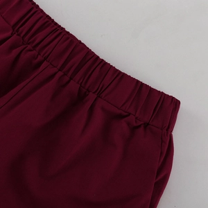 Detail einer weinroten Hose mit elastischem Bund und feiner Plissierung der Textur