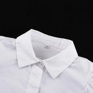Dettaglio del colletto a revers e del bottone su camicia di cotone bianco con taglia M