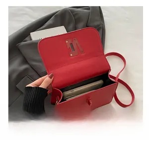 Détail du sac à bandoulière en cuir rouge grainé montrant sa grande capacité interne