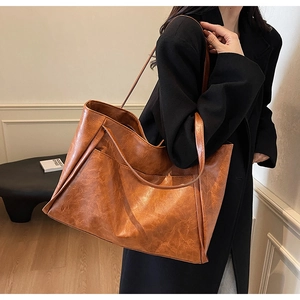 Detailed view of brown vintage leather tote bag with retro oil-wax texture and wide stitching