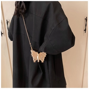 Detailed view of a gold butterfly mini evening bag with sparkling rhinestones and chain