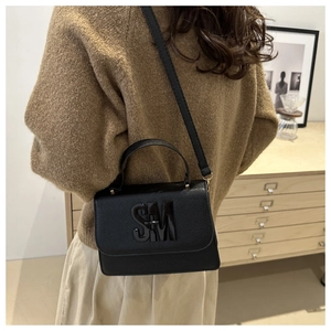 Détail du sac bandoulière en cuir grainé noir avec boucle métallique SM emblématique
