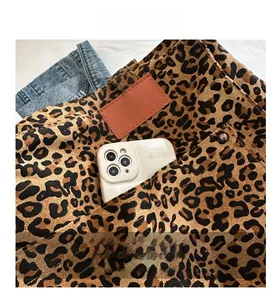 Detail view of large leopard print tote bag showing external pocket and phone storage
